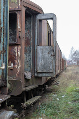 Fototapeta na wymiar Old destroyed railway wagons. Forgotten railway station in central europe.