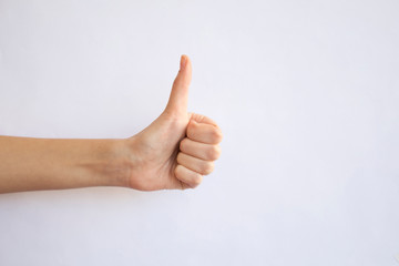 Woman hand with thumb up on gray background