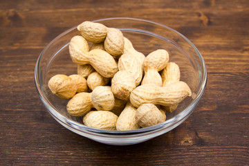 Peanuts on bowl on a wooden table