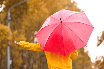Woman with red umbrella outdoors on rainy day