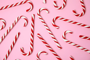 Flat lay composition with tasty candy canes on color background