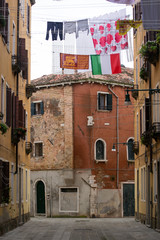 Fototapeta na wymiar A not touristy spot in Venice, italy, november 2018. The beauty of this city is also in the not famous areas where residents are local, exposed here there are two flags , the italian and venetian
