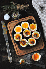 halved boiled eggs with shells. Stylish breakfast with eggs. Keto snack soft boiled eggs.
