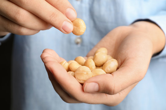 Woman holding shelled organic Macadamia nuts, closeup