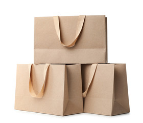 Paper shopping bags with comfortable handles on white background. Mockup for design