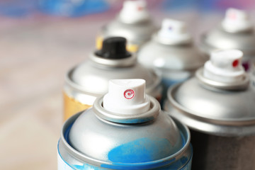 Used cans of spray paint on blurred background, closeup view