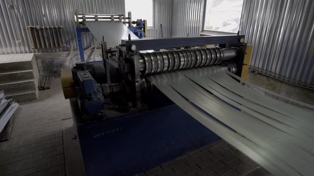 Sheet metal cutting machine for the production of steel pipes. machine for slitting steel sheet. Industrial machine for steel coils cut.