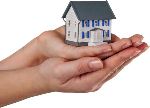 hand with a miniature house model