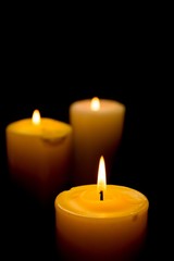Fototapeta na wymiar Close-Up of Three Lit Candles on Black Background