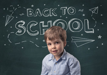 Adorable little boy with blackboard and back to school concept