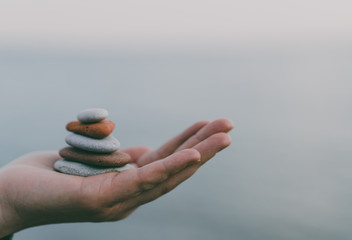 Pile of stacked stones in human hand