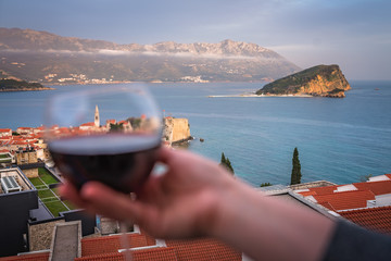 Woman holding glass with red wine