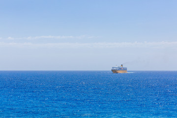 Ferry between Corsica and Nice traveling near horizon over blue sea, near Nice, France