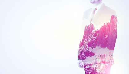  Young businessman in suit standing with sunny snowy mountain and trees graphic.