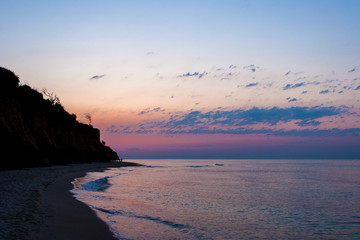 Fototapeta premium Coastal waves in the dawn, The reflection of the setting sun in the waves. Selective focus