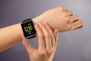 Naked female hand with smart wristwatch and digital clock on the screen 