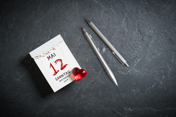 Abreißkalender mit Muttertag 2019 und dekorativem Herzchen auf Schieferhintergrund