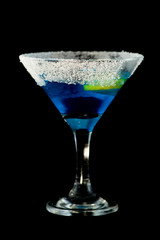 Blue kamikaze cocktail with vodka, lime juice, blue curacao, sugar and lime wedge