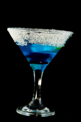 Blue kamikaze cocktail with vodka, lime juice, blue curacao, sugar and lime wedge