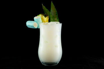 Pina Colada cocktail with pineapple juice, white rum and coconut cream decorated with pineapple fruit and leaf