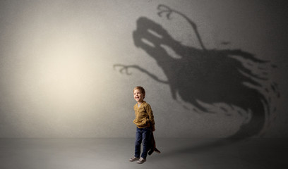 Fototapeta na wymiar Scary ghost shadow in a dark empty room with a cute blond child 