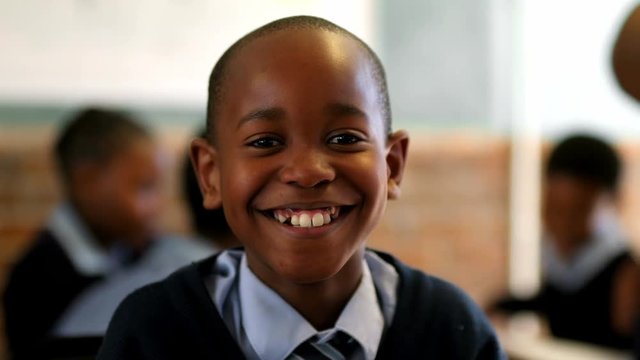 Schoolboy looking at camera in the classroom at school 4k