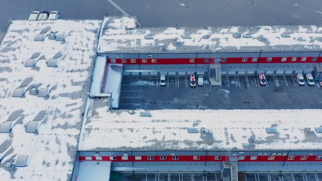 Aerial side view of a modern warehouse logistics park in winter day