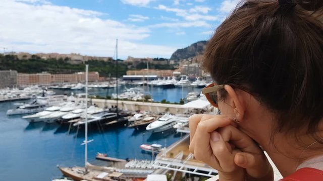 Upset woman looking at expensive yachts in port, wealth gap, unattainable luxury
