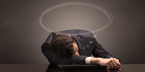 Young businessman sleeping and dreaming at the office
