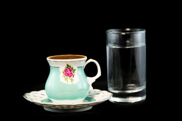 Obraz na płótnie Canvas Turkish coffee and glass of water with isolated black background