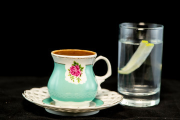 Turkish coffee and glass of water with isolated black background