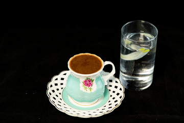 Turkish coffee and glass of water with isolated black background