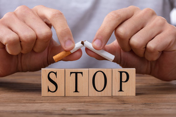 Man Breaking Cigarette Over Stop Blocks