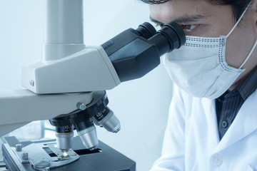 Male scientist doing microscope for chemistry test samples, examining. Laboratory equipment and...