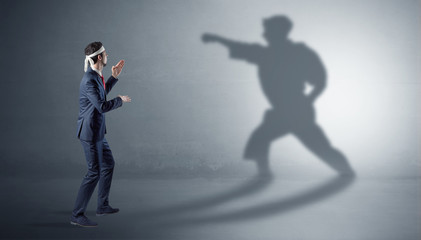 Obraz premium Businessman fighting with his strong karate man shadow 
