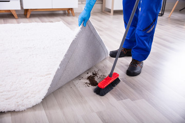 Janitor Cleaning Dirt Under The Carpet