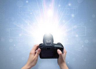 Naked hand taking picture with digital camera and glowing flash concept
