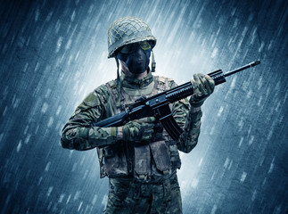 Armed soldier standing in rainy weather
