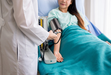 Doctor woman checking patient blood pressure in hospital,Heart rate pressure gauge