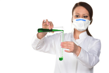 Portrait of busy concentrated scientist with stubble in white lab coat, gloves analysing, looking at test tubes with multi-colored liquid in his arm, isolated on grey background