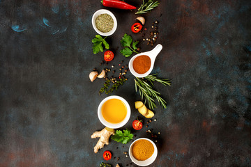 Herbs and spices over dark stone background. Top view. Copy space