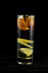 Cuba Libre cocktail with rum, coke and lime juice with lime wedge and full of ices