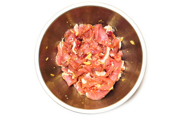 Marinaded pork in a bowl isolated on white background