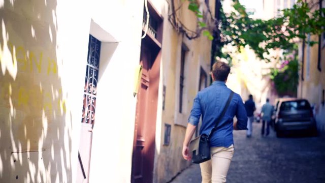 Young Handsome Man Listening Music with a Mobile Phone on the Streets of Rome Italy. 4k 25p 1/50s