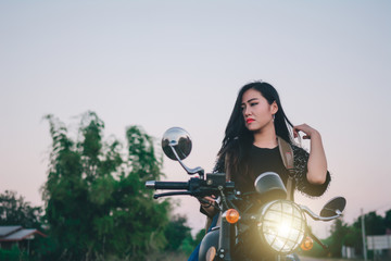 Fototapeta na wymiar Young sexy woman on a motorcycle in nature on the sunset.Travel Concept.