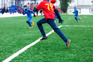 Boys  in red and blue sportswear kicking soccer ball on green grass field. youth football game. Children sport competition, kids plays outdoor, winter activities, training