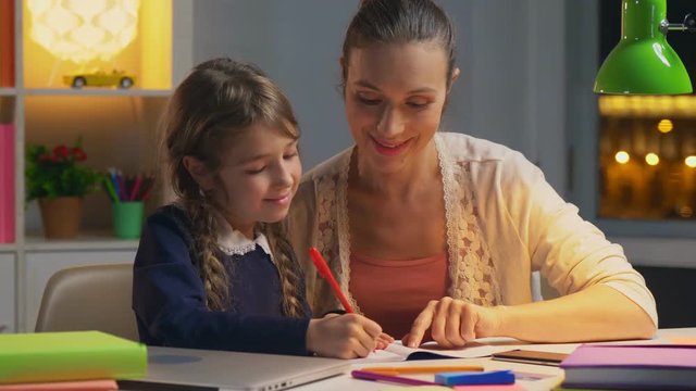 Young mother hepling her daughter with homework