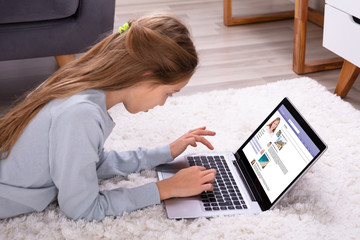 Girl Using Social Networking Site On Laptop