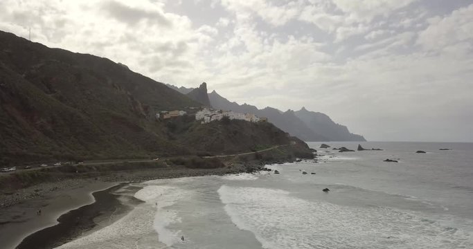 Aerial view of Almaciga in canary Island with surfers in the ocean during a cloudy afternoon
