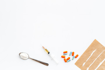 Take drugs, drugs addiction concept. White powder like heroine or cocaine, drug tracks pills, spoon, syringe on white background top view copy space